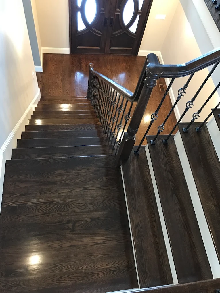 Dark stained stairs with ornate railing