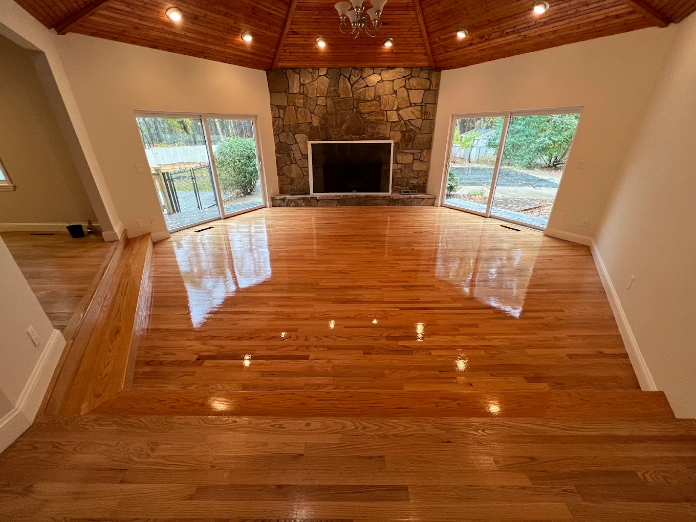 Warm hardwood floor with stone fireplace